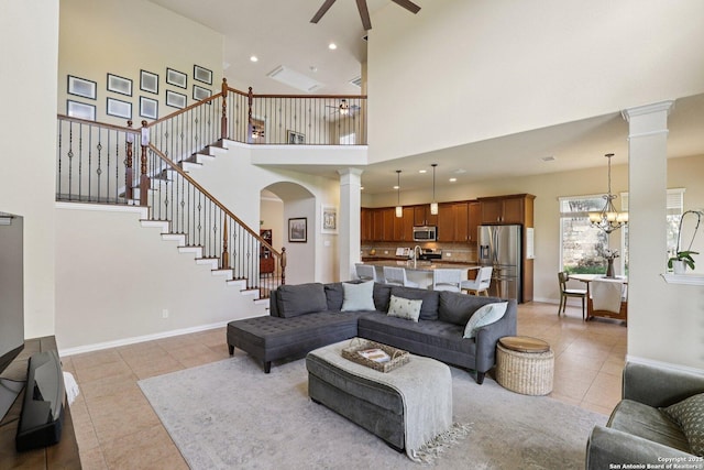 3403 Navajo Peace, San Antonio, TX 78261 - living area with ornate columns, light tile patterned flooring, a towering ceiling, a ceiling fan, and stairs