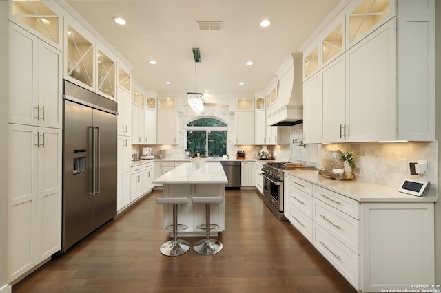 19727 La Sierra Blvd, San Antonio, TX 78256 - kitchen featuring premium appliances, premium range hood, white cabinetry, a kitchen island, and a breakfast bar