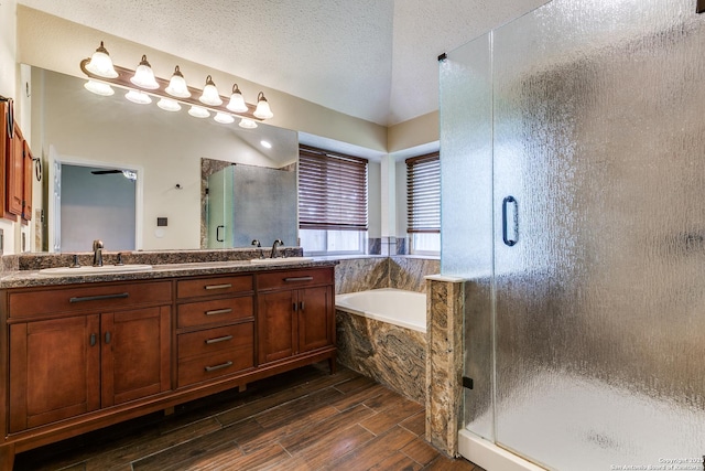 8658 Quail Whisper, San Antonio, TX 78250 - full bathroom with a shower stall, double vanity, a garden tub, wood tiled floors, and a textured ceiling