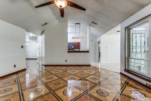 8658 Quail Whisper, San Antonio, TX 78250 - spare room featuring light tile patterned floors, plenty of natural light, ceiling fan, vaulted ceiling, and a textured ceiling