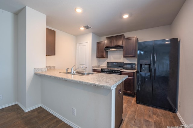 5722 Tanquil Cv, Converse, TX 78109 - kitchen featuring black appliances, under cabinet range hood, light countertops, dark wood-style flooring, and dark brown cabinets