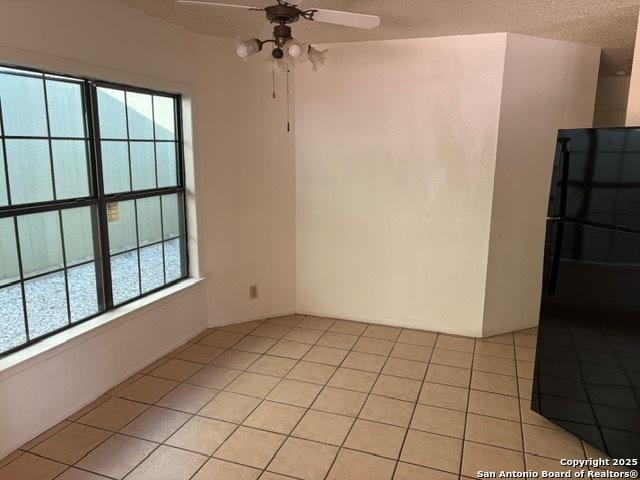9931 Birch Fld, San Antonio, TX 78245 - spare room featuring ceiling fan, plenty of natural light, a textured ceiling, and light tile patterned floors