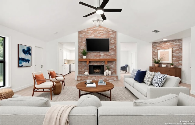 9238 Ridge Wilde, San Antonio, TX 78250 - living area featuring light wood-type flooring, lofted ceiling, a ceiling fan, plenty of natural light, and a brick fireplace