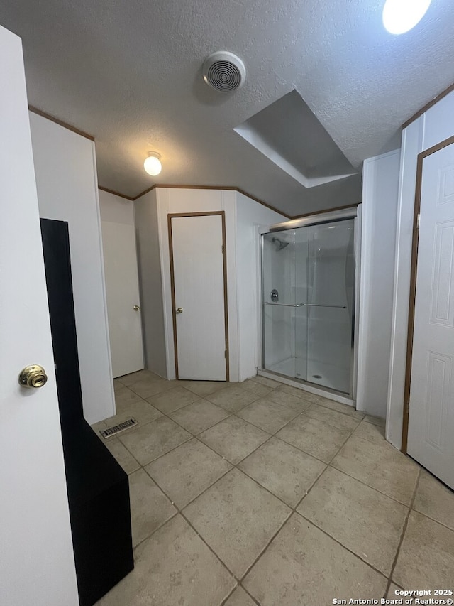 207 S Edwards, Charlotte, TX 78011 - bathroom featuring a shower stall, tile patterned floors, and a textured ceiling