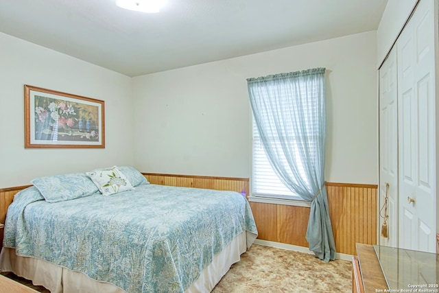323 Hatcher Ave, San Antonio, TX 78223 - bedroom with wood walls, a wainscoted wall, and a closet