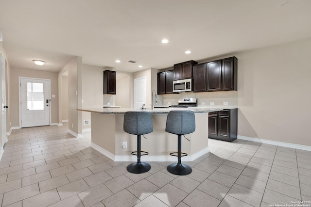 15442 Cooks Petrel, San Antonio, TX 78253 - kitchen with stainless steel appliances, light tile patterned floors, an island with sink, backsplash, and recessed lighting