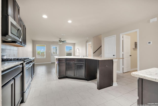 15442 Cooks Petrel, San Antonio, TX 78253 - kitchen with stainless steel appliances, ceiling fan, recessed lighting, a center island with sink, and decorative backsplash