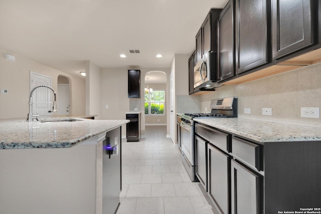 15442 Cooks Petrel, San Antonio, TX 78253 - kitchen with stainless steel appliances, arched walkways, light tile patterned flooring, backsplash, and recessed lighting