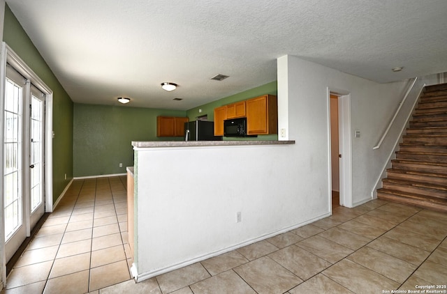 245 Gatewood, Cibolo, TX 78108 - kitchen with black appliances, light tile patterned floors, a textured ceiling, a peninsula, and brown cabinetry