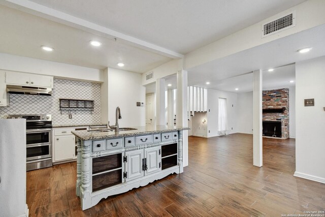 11826 Petal Unit 73, San Antonio, TX 78216 - kitchen featuring under cabinet range hood, range with two ovens, open shelves, tasteful backsplash, and white cabinetry
