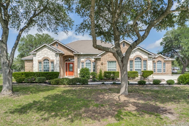15311 Tamaron Pass, San Antonio, TX 78253 - view of front facade featuring stone siding, a front yard, and brick siding