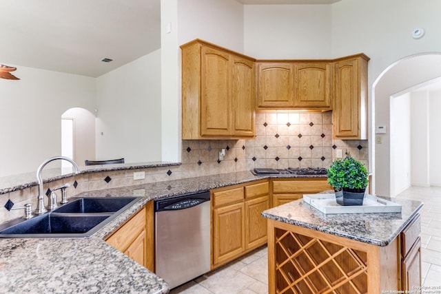 15311 Tamaron Pass, San Antonio, TX 78253 - kitchen with stainless steel dishwasher, arched walkways, backsplash, light stone countertops, and gas cooktop