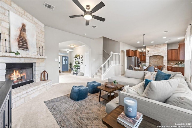 25702 Coleus, San Antonio, TX 78261 - living area with light colored carpet, arched walkways, a stone fireplace, a ceiling fan, and stairway
