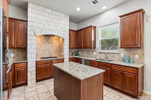 25702 Coleus, San Antonio, TX 78261 - kitchen featuring appliances with stainless steel finishes, light tile patterned floors, a kitchen island, backsplash, and light stone counters