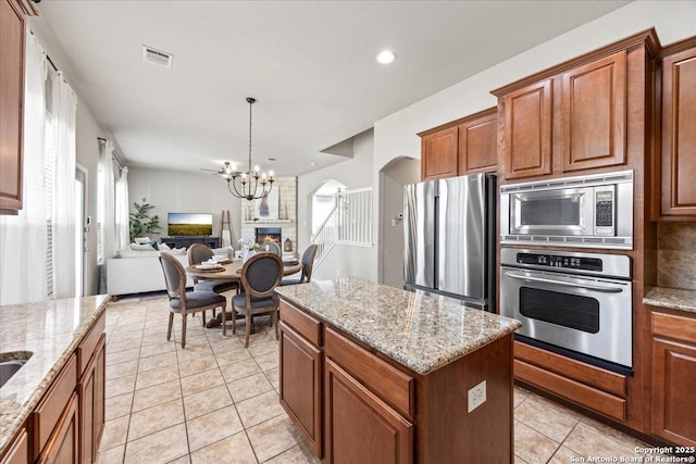 25702 Coleus, San Antonio, TX 78261 - kitchen with appliances with stainless steel finishes, arched walkways, a chandelier, open floor plan, and light tile patterned flooring