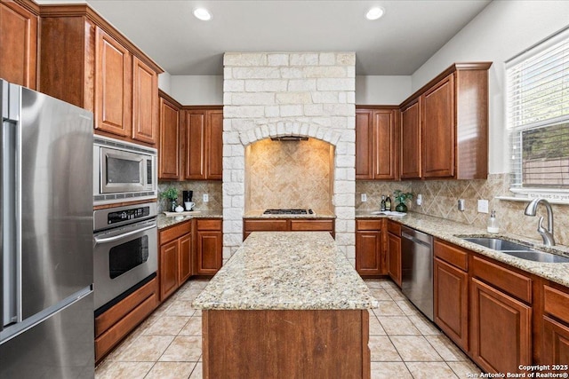 25702 Coleus, San Antonio, TX 78261 - kitchen with appliances with stainless steel finishes, a center island, light stone countertops, light tile patterned floors, and backsplash