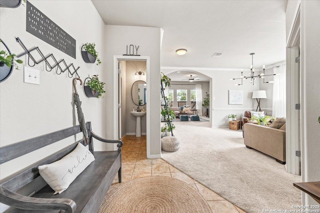 25702 Coleus, San Antonio, TX 78261 - corridor featuring light colored carpet, a chandelier, light tile patterned floors, and arched walkways