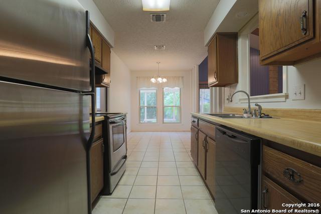 9218 Woodheather, San Antonio, TX 78254 - kitchen featuring stainless steel appliances, a chandelier, brown cabinets, and light countertops