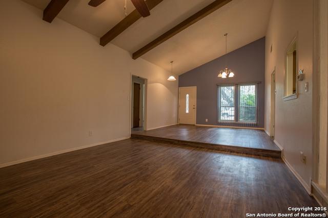 9218 Woodheather, San Antonio, TX 78254 - spare room featuring dark wood finished floors, high vaulted ceiling, beamed ceiling, a ceiling fan, and a chandelier