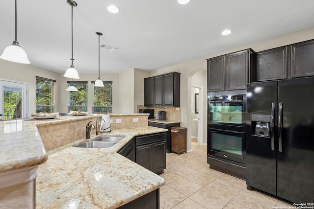 20630 Creek Riv, San Antonio, TX 78259 - kitchen featuring black appliances, light stone counters, tasteful backsplash, light tile patterned floors, and arched walkways
