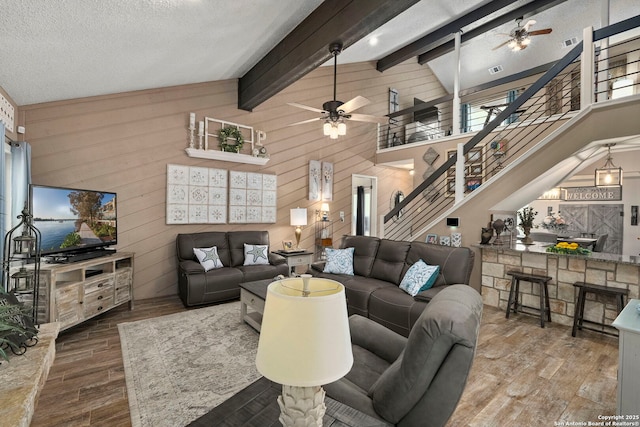 2026 Encino Vista St, San Antonio, TX 78259 - living area with ceiling fan, wood finished floors, stairway, wooden walls, and beam ceiling