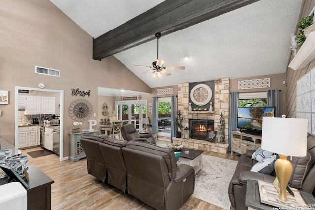 2026 Encino Vista St, San Antonio, TX 78259 - living area with a ceiling fan, beamed ceiling, a stone fireplace, light wood-style floors, and high vaulted ceiling
