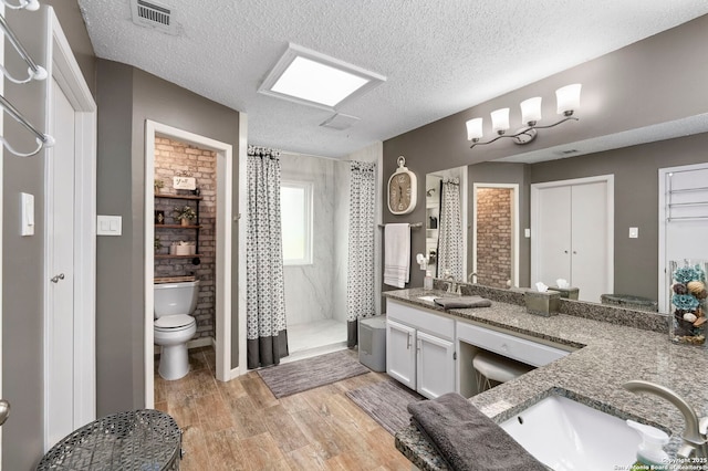 2026 Encino Vista St, San Antonio, TX 78259 - full bath featuring double vanity, curtained shower, wood finished floors, and a textured ceiling