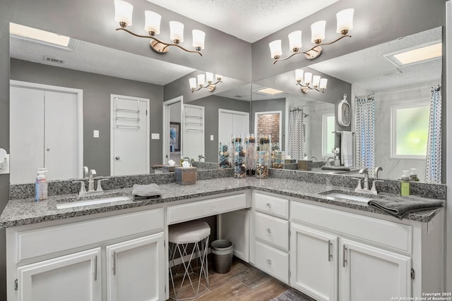 2026 Encino Vista St, San Antonio, TX 78259 - full bathroom featuring a textured ceiling, double vanity, wood finished floors, and curtained shower