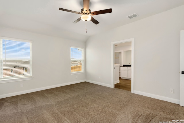 6509 Titan Park, Converse, TX 78109 - unfurnished bedroom with carpet, multiple windows, ensuite bath, and vaulted ceiling