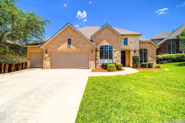 139 Sable Hts, San Antonio, TX 78258 - view of front of home with brick siding, an attached garage, concrete driveway, stone siding, and roof with shingles