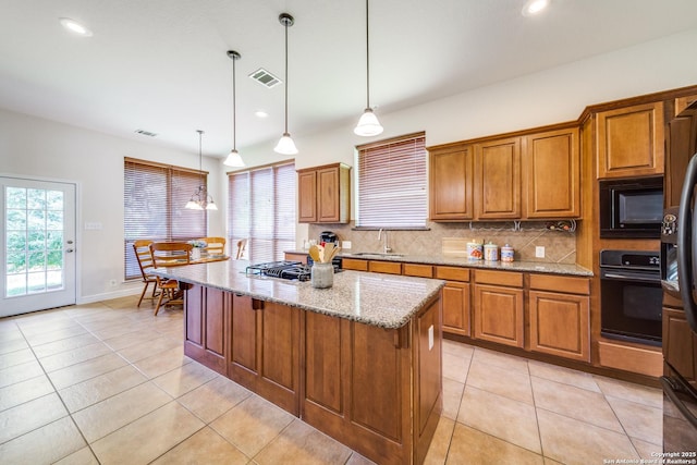 139 Sable Hts, San Antonio, TX 78258 - kitchen with black appliances, brown cabinets, tasteful backsplash, light stone counters, and plenty of natural light
