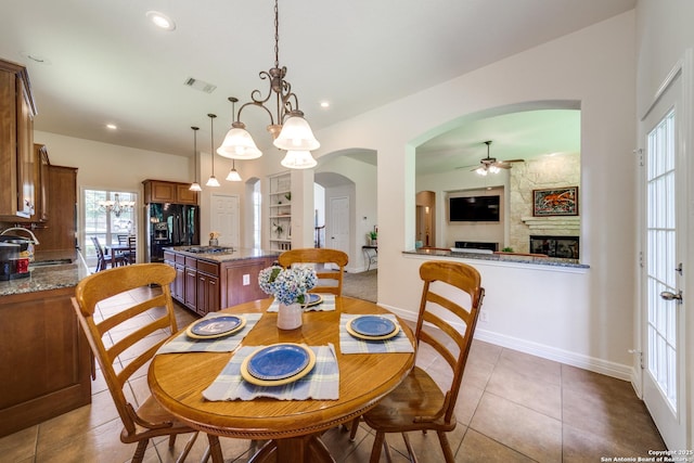 139 Sable Hts, San Antonio, TX 78258 - dining space with ceiling fan, arched walkways, dark tile patterned floors, a fireplace, and recessed lighting