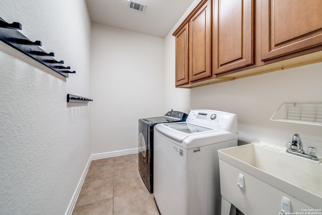 139 Sable Hts, San Antonio, TX 78258 - washroom with independent washer and dryer, cabinet space, light tile patterned floors, and a textured wall