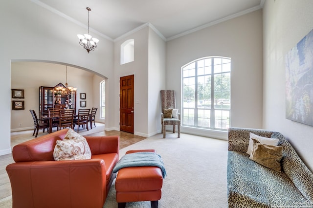 139 Sable Hts, San Antonio, TX 78258 - carpeted living area featuring arched walkways, a chandelier, a towering ceiling, and ornamental molding
