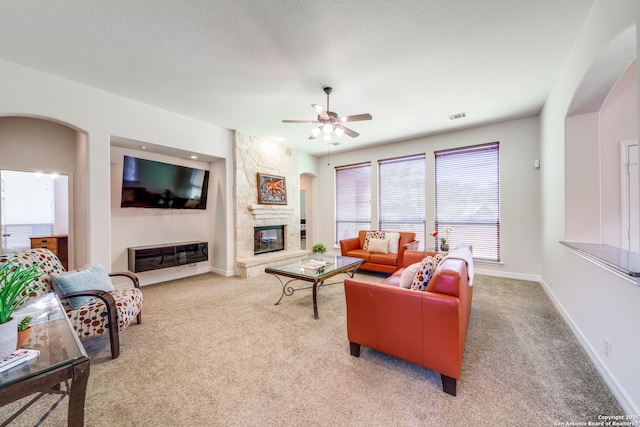 139 Sable Hts, San Antonio, TX 78258 - living area featuring light colored carpet, ceiling fan, a stone fireplace, and arched walkways