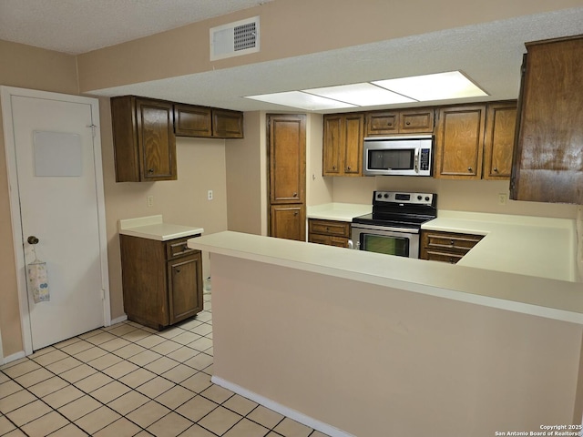 14107 Moss Farm, San Antonio, TX 78231 - kitchen with appliances with stainless steel finishes, light countertops, a peninsula, and light tile patterned floors
