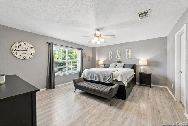 811 Cormorant, San Antonio, TX 78245 - bedroom featuring light wood-type flooring, a textured ceiling, and a ceiling fan