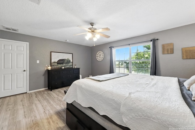 811 Cormorant, San Antonio, TX 78245 - bedroom with light wood-style floors, ceiling fan, and a textured ceiling