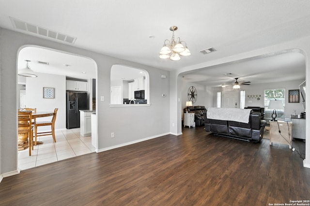 811 Cormorant, San Antonio, TX 78245 - living room with arched walkways, wood finished floors, ceiling fan, and a chandelier