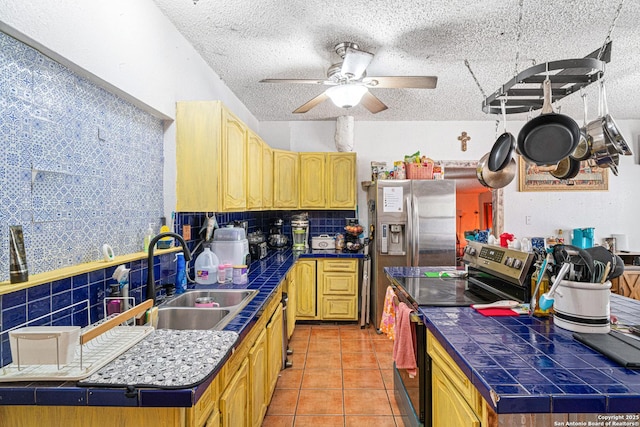 114 Pace Miller, Del Rio, TX 78840 - kitchen with electric stove, tile countertops, decorative backsplash, ceiling fan, and a textured ceiling
