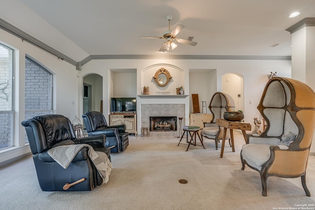 13947 Amber Crst, San Antonio, TX 78249 - living area with ornamental molding, ceiling fan, light colored carpet, arched walkways, and a tile fireplace