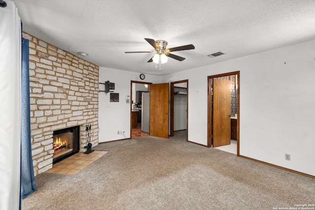 25615 Dull Knife Trl, San Antonio, TX 78255 - unfurnished living room featuring carpet flooring, ceiling fan, a fireplace, and a textured ceiling