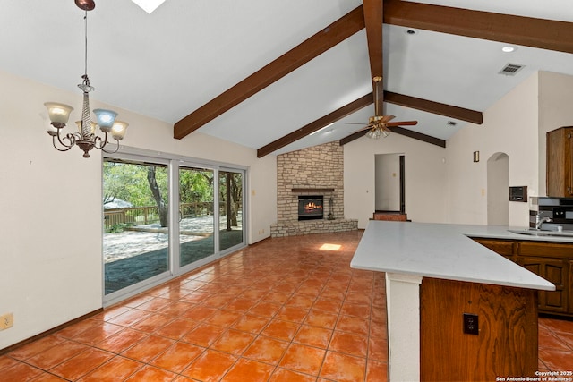 25615 Dull Knife Trl, San Antonio, TX 78255 - kitchen with beam ceiling, light tile patterned floors, ceiling fan, a fireplace, and hanging light fixtures