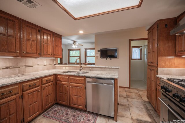 14519 Parksite Woods, San Antonio, TX 78249 - kitchen with dishwasher, range, brown cabinets, decorative backsplash, and a peninsula
