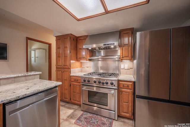 14519 Parksite Woods, San Antonio, TX 78249 - kitchen featuring appliances with stainless steel finishes, wall chimney exhaust hood, backsplash, and brown cabinetry