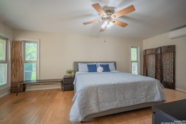 14519 Parksite Woods, San Antonio, TX 78249 - bedroom featuring a wall mounted air conditioner, multiple windows, and light wood finished floors