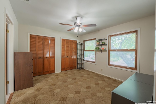 14519 Parksite Woods, San Antonio, TX 78249 - unfurnished bedroom with two closets, light carpet, and a ceiling fan
