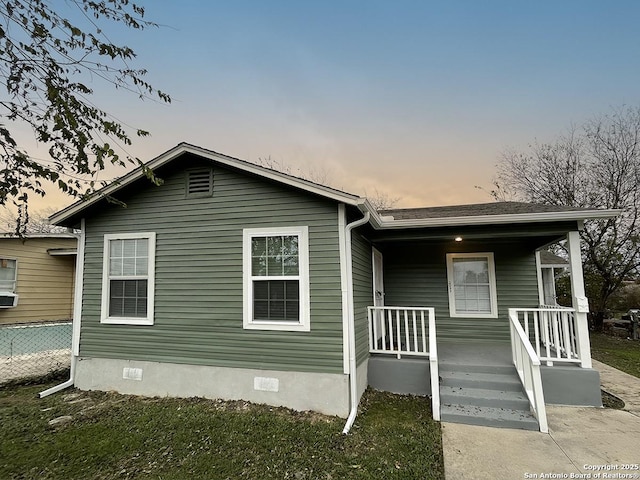 2025 Texas, San Antonio, TX 78228 - back of house at dusk with covered porch and crawl space