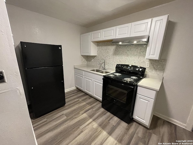 2025 Texas, San Antonio, TX 78228 - kitchen featuring black appliances, under cabinet range hood, light wood finished floors, decorative backsplash, and light countertops