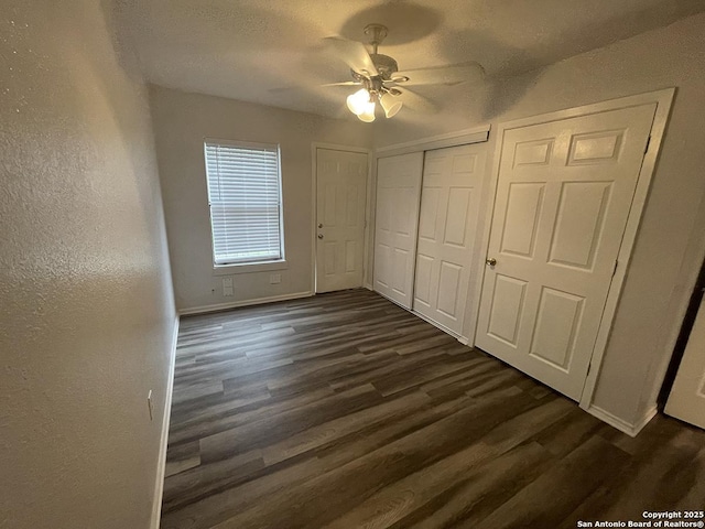 2025 Texas, San Antonio, TX 78228 - unfurnished bedroom with dark wood-style floors, a ceiling fan, a closet, and a textured wall